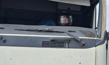 PRF flagra carreta sem para-brisas, caminhoneiro de capacete e peças amarradas com cordas